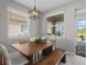 Bright dining room features a wood table, bench, and access to the pool at 11550 Blackfin St, Venice, FL 34292