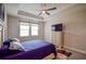 Bright bedroom with a ceiling fan, TV, and double windows at 11786 Sistine Ln, Venice, FL 34293