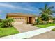 Tan house with beige garage door, landscaping, and paver driveway at 11786 Sistine Ln, Venice, FL 34293