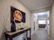 Bright hallway with dark console table, moon art, and view to living room at 11786 Sistine Ln, Venice, FL 34293