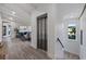 Elegant hallway with elevator access, hardwood floors, and views of a living area at 150 Grant Dr, Sarasota, FL 34236