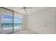 A bright bedroom with carpet, a ceiling fan, and sliding glass doors with a view to the ocean at 1800 Benjamin Franklin Dr # A405, Sarasota, FL 34236