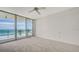 Bedroom with carpet, a ceiling fan, and floor to ceiling sliding glass doors to a beautiful beach view at 1800 Benjamin Franklin Dr # A405, Sarasota, FL 34236