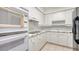 Clean white kitchen with modern appliances and tiled backsplash at 1800 Benjamin Franklin Dr # A405, Sarasota, FL 34236