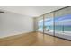 Spacious, bright living room with wood floors and large windows showcasing a beautiful ocean view at 1800 Benjamin Franklin Dr # A405, Sarasota, FL 34236