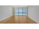 Bright living room with wood floors and sliding glass doors offering stunning ocean views and access to the balcony at 1800 Benjamin Franklin Dr # A405, Sarasota, FL 34236