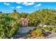 An aerial view of a charming house with a paved driveway and tropical landscaping at 235 Grant Dr, Sarasota, FL 34236