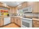 Efficient kitchen with white appliances and light wood cabinets at 235 Grant Dr, Sarasota, FL 34236