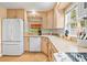 Galley-style kitchen with white appliances and light wood cabinets at 235 Grant Dr, Sarasota, FL 34236