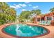 Inviting kidney-shaped pool with lounge chairs in a tropical setting at 235 Grant Dr, Sarasota, FL 34236