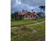 Tan house with red roof, palm trees, and a grassy yard at 2502 Riverside E Dr, Bradenton, FL 34208