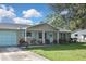 Tan house with light blue accents, a double garage door, and a manicured lawn at 3111 Taunton W Dr, Bradenton, FL 34205