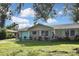 Tan house with light blue accents, a double garage door, and a large yard at 3111 Taunton W Dr, Bradenton, FL 34205