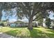 House with a large oak tree in the front yard, light blue accents, and a manicured lawn at 3111 Taunton W Dr, Bradenton, FL 34205