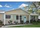 Tan house with light blue accents, a double garage door, and a well-maintained lawn at 3111 Taunton W Dr, Bradenton, FL 34205