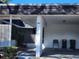 View of the carport with a small seating area and trash cans at 3911 Panola Ln # 192, Sarasota, FL 34232