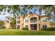 Back view of a condo building showcasing a grassy area and screened balconies at 4142 Central Sarasota Pkwy # 1428, Sarasota, FL 34238