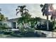 Single-story home with tile roof, palm trees, and landscaped yard at 479 Summerfield Way, Venice, FL 34292
