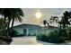 One-story house with tile roof, lush landscaping, and palm trees at 479 Summerfield Way, Venice, FL 34292