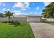 Single-Gathering home with a white garage door and manicured lawn at 5164 Windward Ave, Sarasota, FL 34242