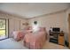 Bright bedroom with two twin beds, patio access, and built-in dresser at 6542 Draw Ln # 90, Sarasota, FL 34238