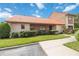 Exterior of a Spanish-style condo with a tiled roof, landscaping, and walkway at 6542 Draw Ln # 90, Sarasota, FL 34238