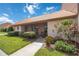 Front view of a condo with a tiled roof, landscaping, and walkway at 6542 Draw Ln # 90, Sarasota, FL 34238