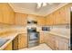 L-shaped kitchen with wood cabinets, stainless steel appliances, and tiled floor at 6542 Draw Ln # 90, Sarasota, FL 34238
