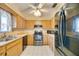 L-shaped kitchen with wood cabinets, stainless steel appliances, and tiled floor at 6542 Draw Ln # 90, Sarasota, FL 34238