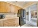 L-shaped kitchen with wood cabinets, stainless steel appliances, and tiled floor at 6542 Draw Ln # 90, Sarasota, FL 34238