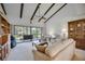 Spacious living room with vaulted ceiling, exposed beams, and sliding glass doors at 6542 Draw Ln # 90, Sarasota, FL 34238