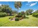 Peaceful pondside view with lush landscaping and a palm tree at 6542 Draw Ln # 90, Sarasota, FL 34238