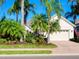 Single-story home with light beige walls, lush landscaping, and a two-car garage at 7131 Sandhills Pl, Lakewood Ranch, FL 34202