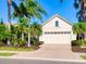 Light beige house with a large two-car garage and palm trees at 7131 Sandhills Pl, Lakewood Ranch, FL 34202