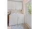Bright laundry room, complete with washer, dryer, and storage cabinets at 7705 Alhambra Dr, Bradenton, FL 34209