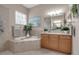 Spa-like bathroom with soaking tub, double vanity, and window at 9203 Winter Harbour Way, Bradenton, FL 34212