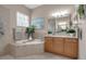 Spa-like bathroom featuring a soaking tub, dual vanities, and large mirror at 9203 Winter Harbour Way, Bradenton, FL 34212