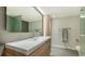 Modern bathroom with wood vanity and a large mirror at 988 Blvd Of The Arts # 311, Sarasota, FL 34236