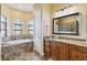 Spa-like bathroom featuring a soaking tub and granite double vanity at 1111 Socorro Dr, Punta Gorda, FL 33950