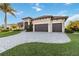 Beautiful Mediterranean home with lush landscaping and a paved driveway leading to a two-car garage at 1111 Socorro Dr, Punta Gorda, FL 33950