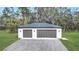 Two-car garage with dark gray doors and a shingle roof at 15125 Waterline Rd, Bradenton, FL 34212