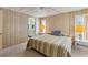 Main bedroom with striped bedding and ensuite bathroom at 1523 46Th E Ave, Ellenton, FL 34222