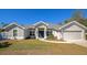 Single-story home with gray exterior, two-car garage, and landscaped lawn at 2155 Jagust Rd, North Port, FL 34288
