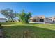 Spacious backyard with grassy area, screened patio, and mature trees at 2505 Riverbluff Pkwy # V196, Sarasota, FL 34231