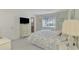 Bedroom with floral bedding, dresser, and view of a bathroom at 2505 Riverbluff Pkwy # V196, Sarasota, FL 34231