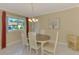 Charming dining room with an oval table, white chairs, and a chandelier at 2505 Riverbluff Pkwy # V196, Sarasota, FL 34231
