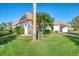 Exterior view of villa with manicured lawn and palm tree at 2505 Riverbluff Pkwy # V196, Sarasota, FL 34231