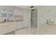 Functional kitchen featuring white cabinets, granite counters, and a view of a hallway at 2505 Riverbluff Pkwy # V196, Sarasota, FL 34231