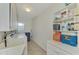 Convenient laundry room with washer, dryer, utility sink, and shelving at 2505 Riverbluff Pkwy # V196, Sarasota, FL 34231