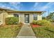Front view of a light beige house with gray accents, landscaped lawn, and walkway at 2709 60Th Avenue N Plz # D, Bradenton, FL 34207